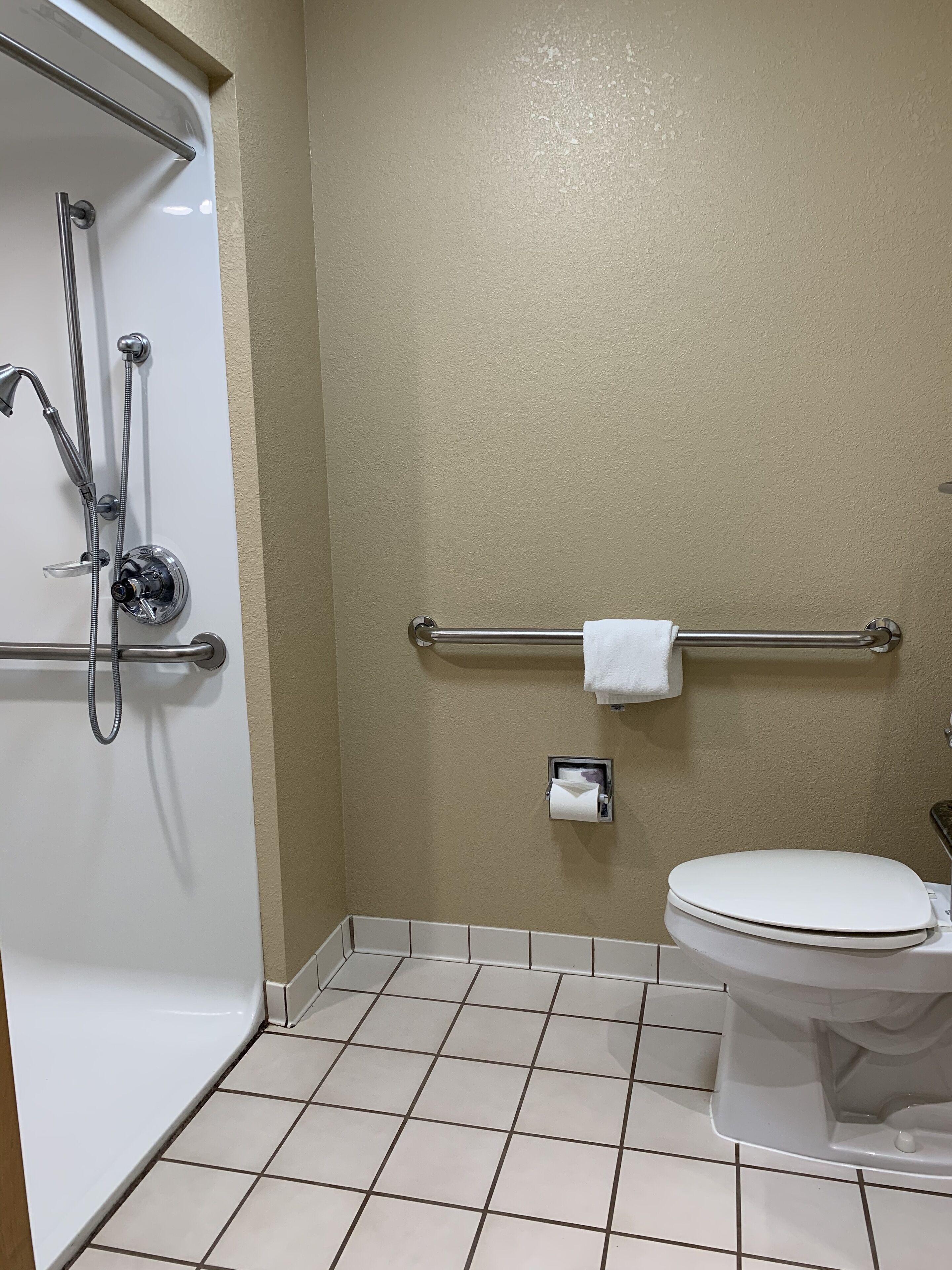 A bathroom with a white bathtub, a toilet, and a towel rack.