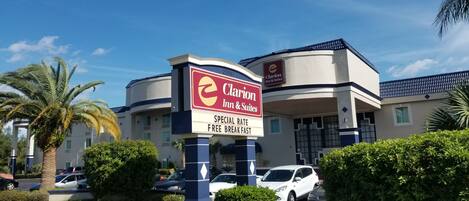 Un hôtel Clarion Inn & Suites avec une enseigne annonçant un tarif spécial et un petit-déjeuner gratuit.