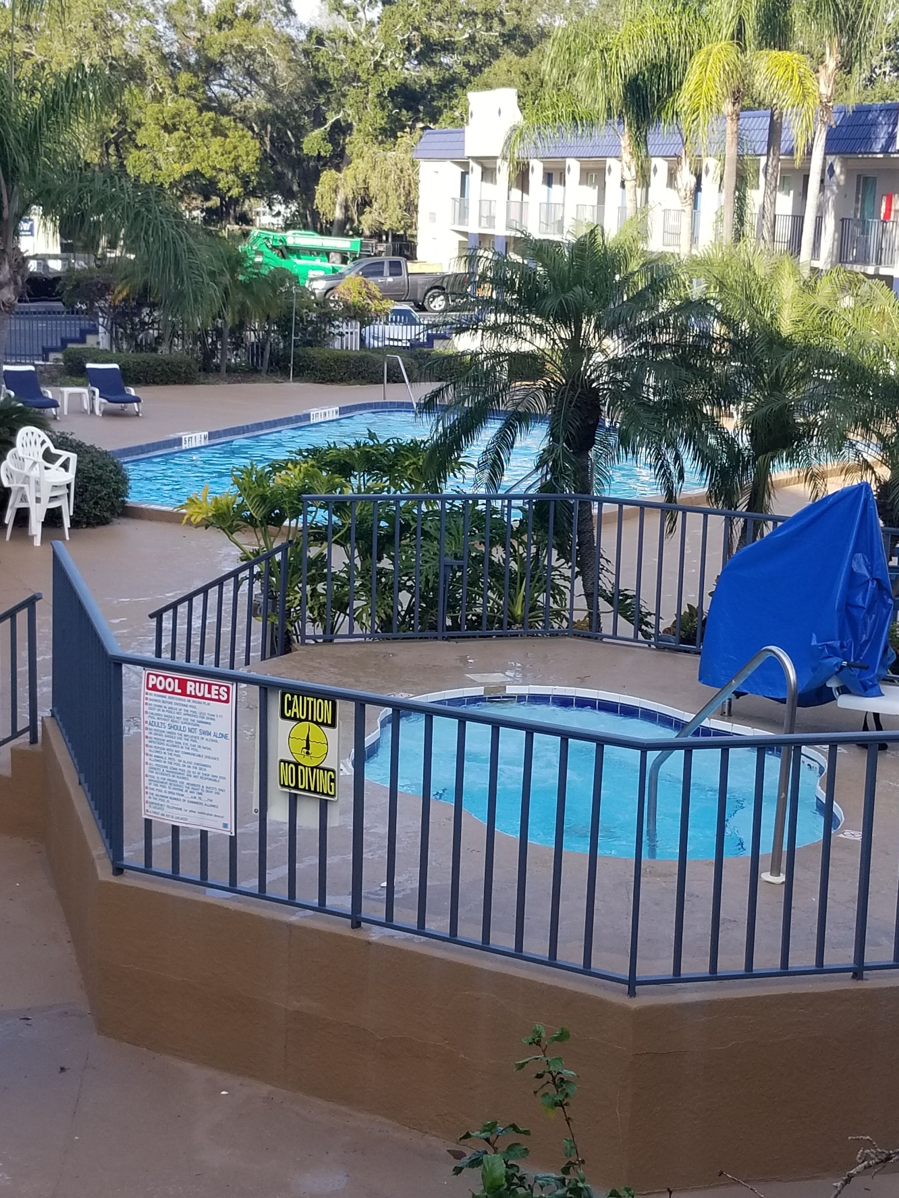 Zona de piscina con un cartel que indica prohibido bucear y normas de la piscina.