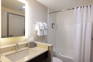 A bathroom with a sink, mirror, towel rack, and shower curtain.