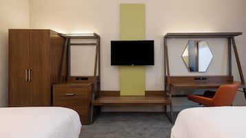 A hotel room with two beds, a desk, a television, and a wardrobe.