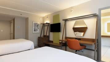 A hotel room with two beds, a desk with a chair, a television, and a mirror.
