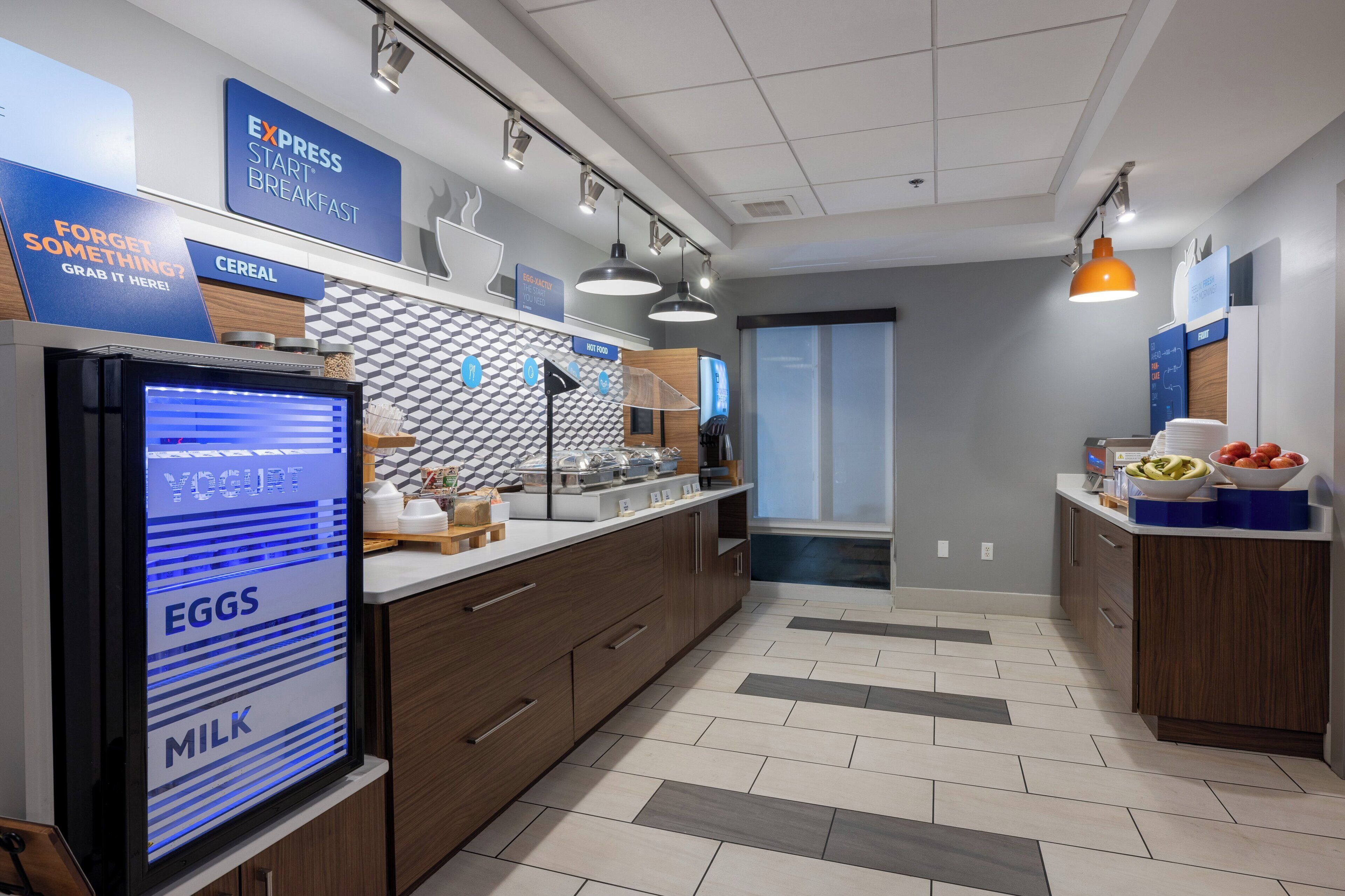 Una cocina moderna con pantalla digital para los alimentos, una barra de desayuno y una ventana con vistas.