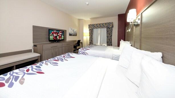 A hotel room with two beds, a TV, a desk, and a chair. - Red Roof Inn Yemassee (Yemassee)