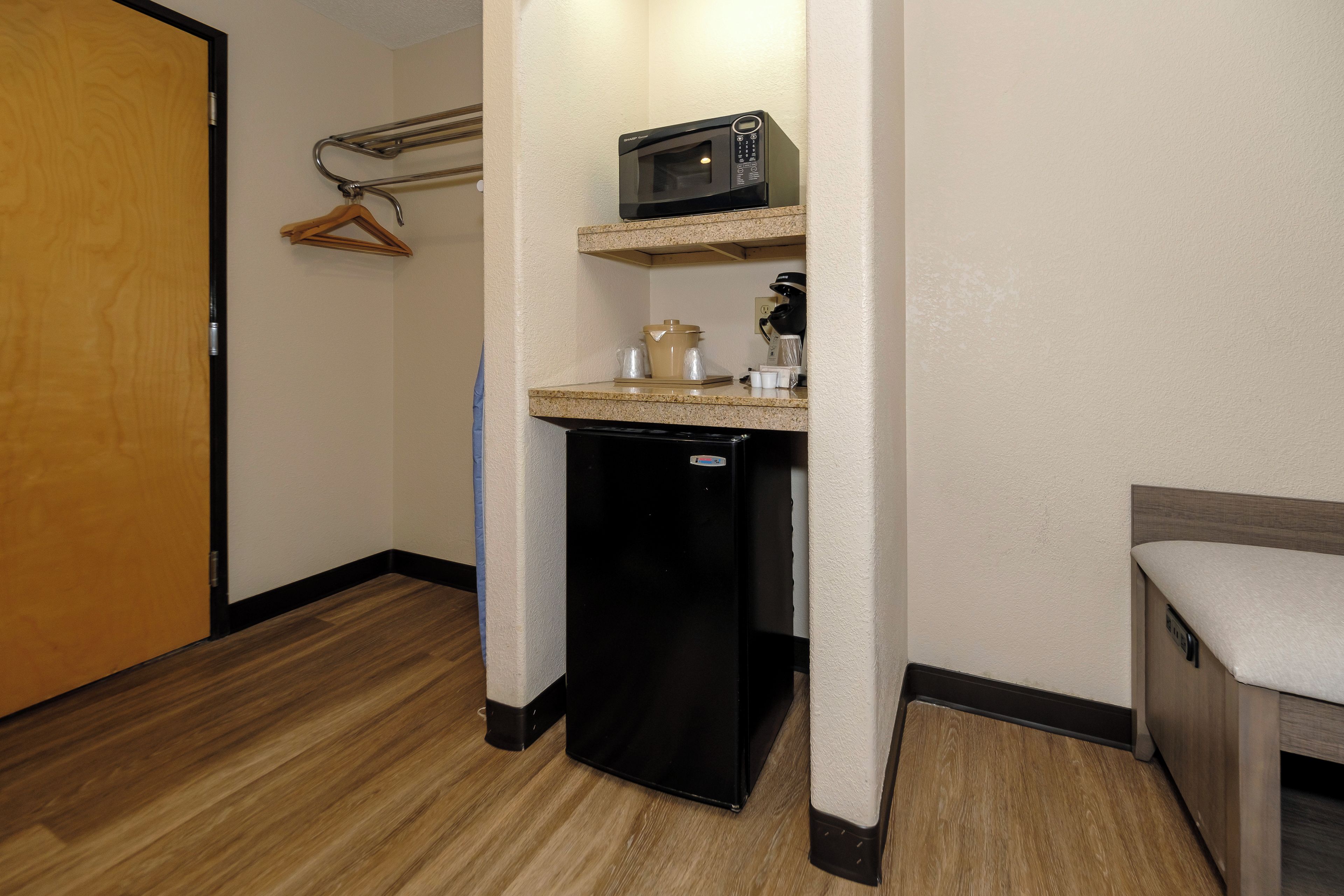 A compact kitchenette with a microwave, coffee maker, and a small refrigerator.