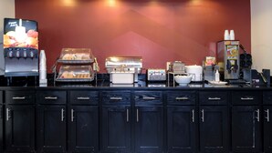 A self-service breakfast station with a coffee machine, a toaster, and a beverage dispenser. - Red Roof Inn Yemassee (Yemassee)