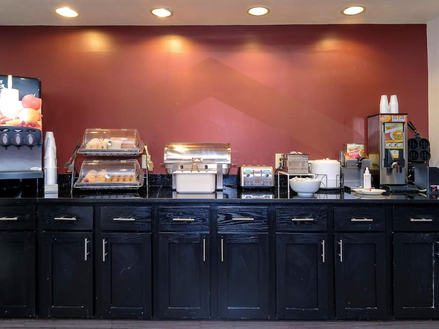 Estação de pequeno-almoço com serviço livre, incluindo máquina de café, torradeira e dispensador de bebidas.