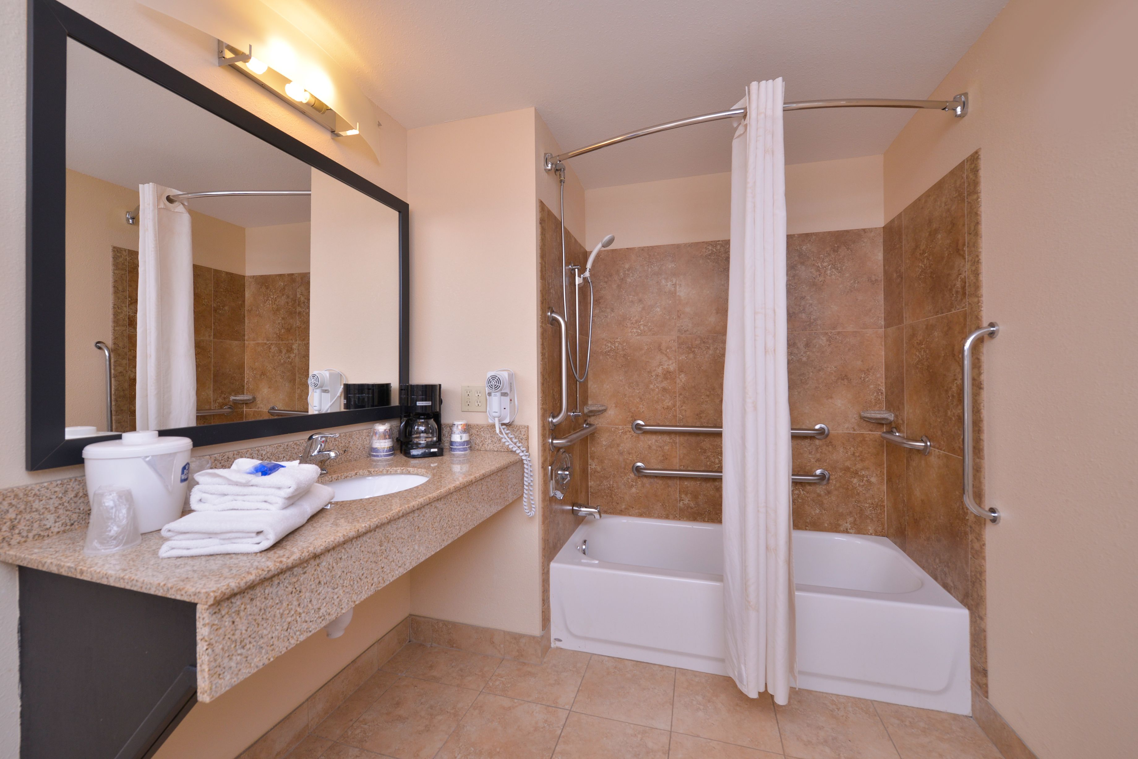 A bathroom with a sink, mirror, and bathtub.