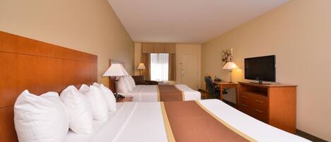 A hotel room with two beds, a TV, a desk, and a chair.