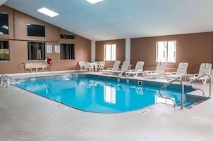 Una piscina techada, sillones reclinables de piscina