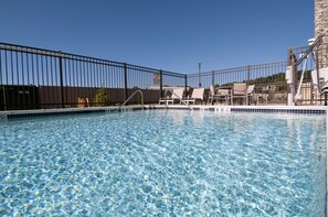 Una piscina al aire libre de temporada, sillones reclinables de piscina