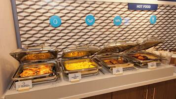 A buffet with labeled food options including scrambled eggs, sausage gravy, turkey sausage, and egg white & veggie omelet.