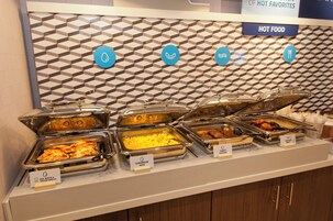 Un bufé con opciones de comida identificadas, incluyendo huevos revueltos, salsa de salchicha, salchicha de pavo y tortilla de claras de huevo y vegetales.
