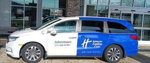 A white and blue van with "Johnstown" and "Holiday Inn Express & Suites" branding parked in front of a building. - Holiday Inn Express & Suites Johnstown by IHG (Johnstown)
