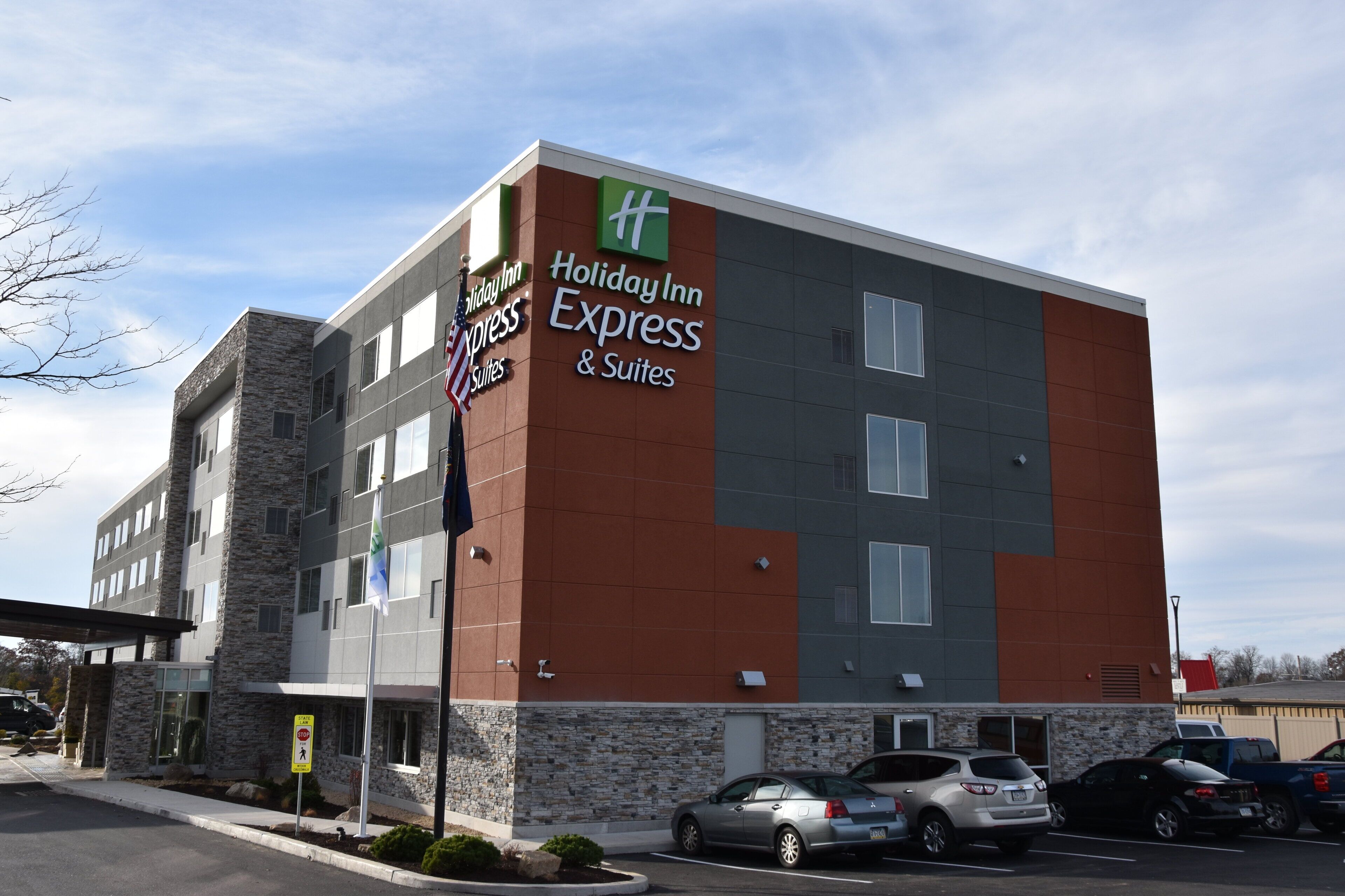 A Holiday Inn Express & Suites building with a stone facade and multiple windows.