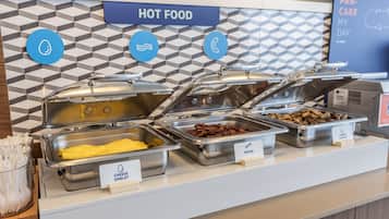 Un buffet proposant différents plats, chacun étant clairement identifié, notamment des omelettes, du bacon et des saucisses de dinde.
