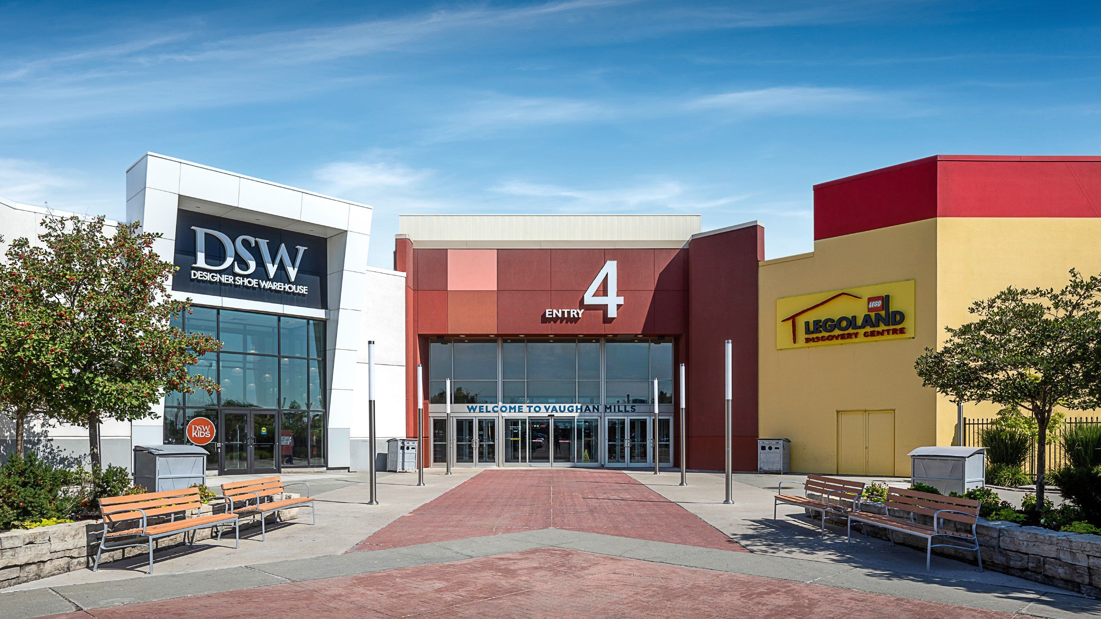Un bâtiment moderne avec une entrée bien visible, une enseigne indiquant « DSW Designer Shoe Warehouse » et une autre indiquant « Legoland Discovery Centre ».