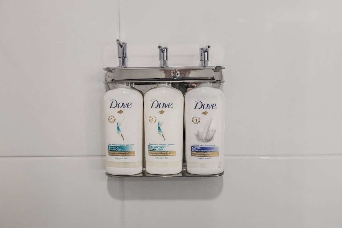 Three Dove body wash bottles mounted on a wall.