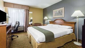 Ein Hotelzimmer mit Bett, Schreibtisch, Stuhl und zwei Lampen.