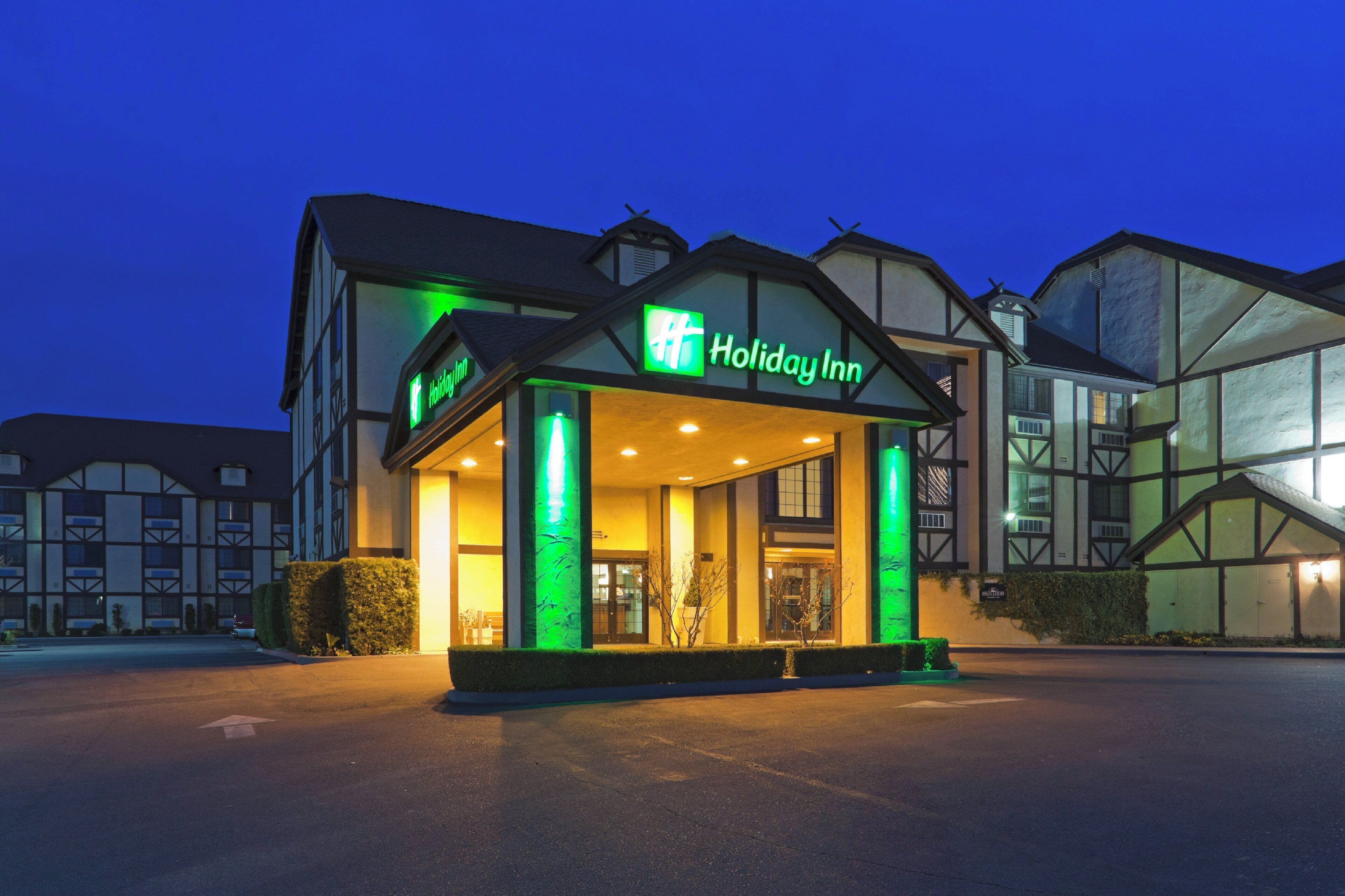 A Holiday Inn hotel with a traditional architectural style, featuring a prominent entrance with illuminated signage.