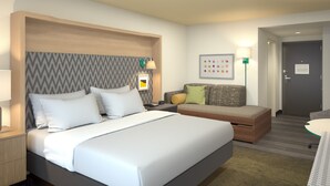 Ein Hotelzimmer mit einem großen Bett, einem Nachttisch, einer kleinen Couch, einer Lampe und einem Wandbild.