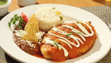 A plate of food with rice, beans, a tortilla dish, and a side of salsa.