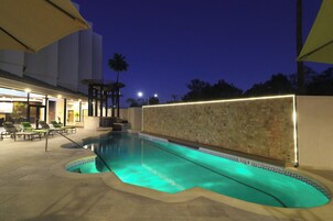 Una piscina al aire libre, tumbonas