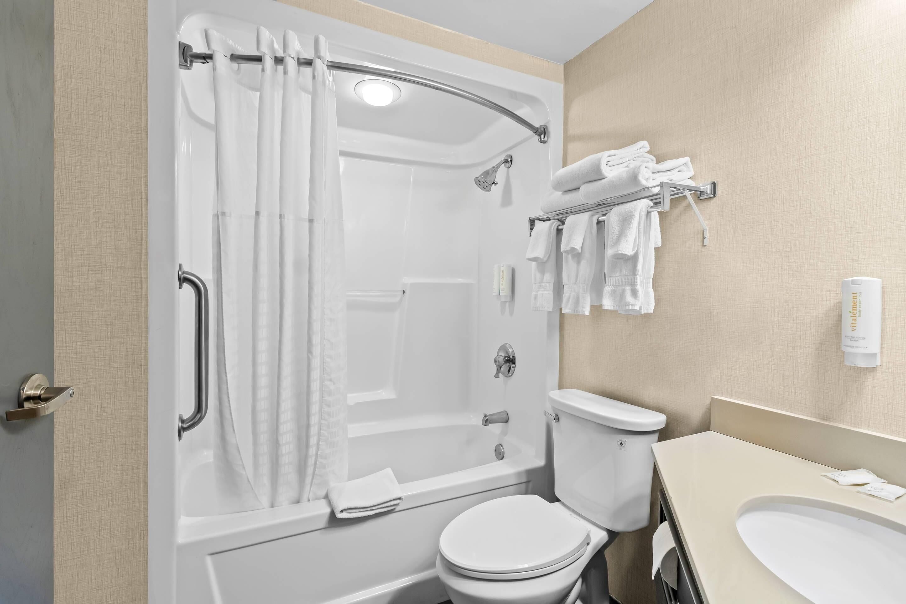 A modern bathroom with a bathtub, toilet, and sink.