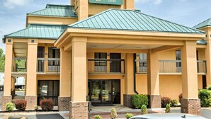 A hotel with a sign reading "Quality Inn" and a covered entrance with a balcony. - Quality Inn Thornburg (Woodford)