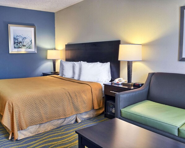 A hotel room with a bed, two bedside tables, a chair, and a desk.