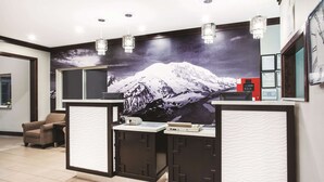 A reception desk with a mountain mural, a chair, and a red phone.