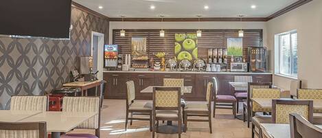 A restaurant with a bar area, seating, and a TV screen.