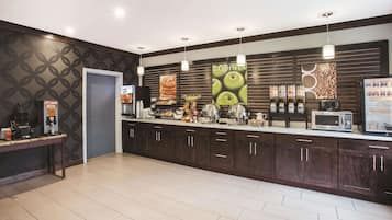 A modern kitchen with dark wood cabinets, a microwave, and a coffee machine.