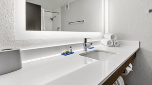 A modern bathroom with a large mirror, two sinks, and a shower area. - Holiday Inn Express Harlingen by IHG (Harlingen)