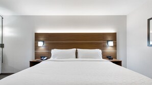 A modern hotel room with a large bed, wooden headboard, two bedside tables with lamps, and a simple, clean design. - Holiday Inn Express Harlingen by IHG (Harlingen)