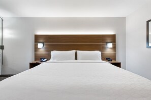 A modern hotel room with a large bed, wooden headboard, two bedside tables with lamps, and a simple, clean design. - Holiday Inn Express Harlingen by IHG (Harlingen)