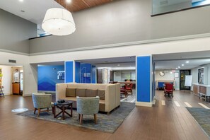 A spacious lobby with a seating area, a reception desk, and a dining area.