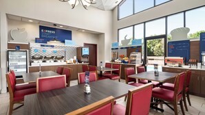 A modern breakfast area with seating, a counter for hot food, and a view of the outdoors.
