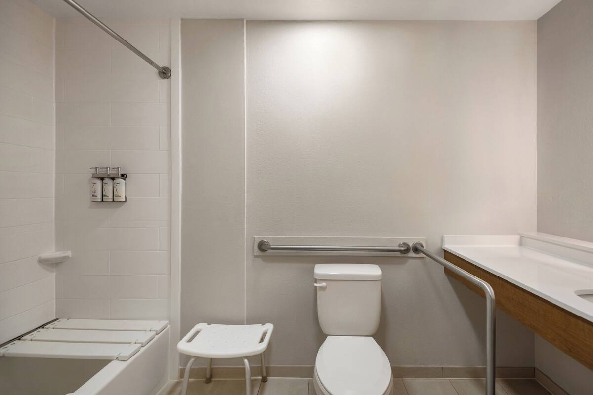 Ein Badezimmer mit Toilette, Duschbereich und Waschbecken.