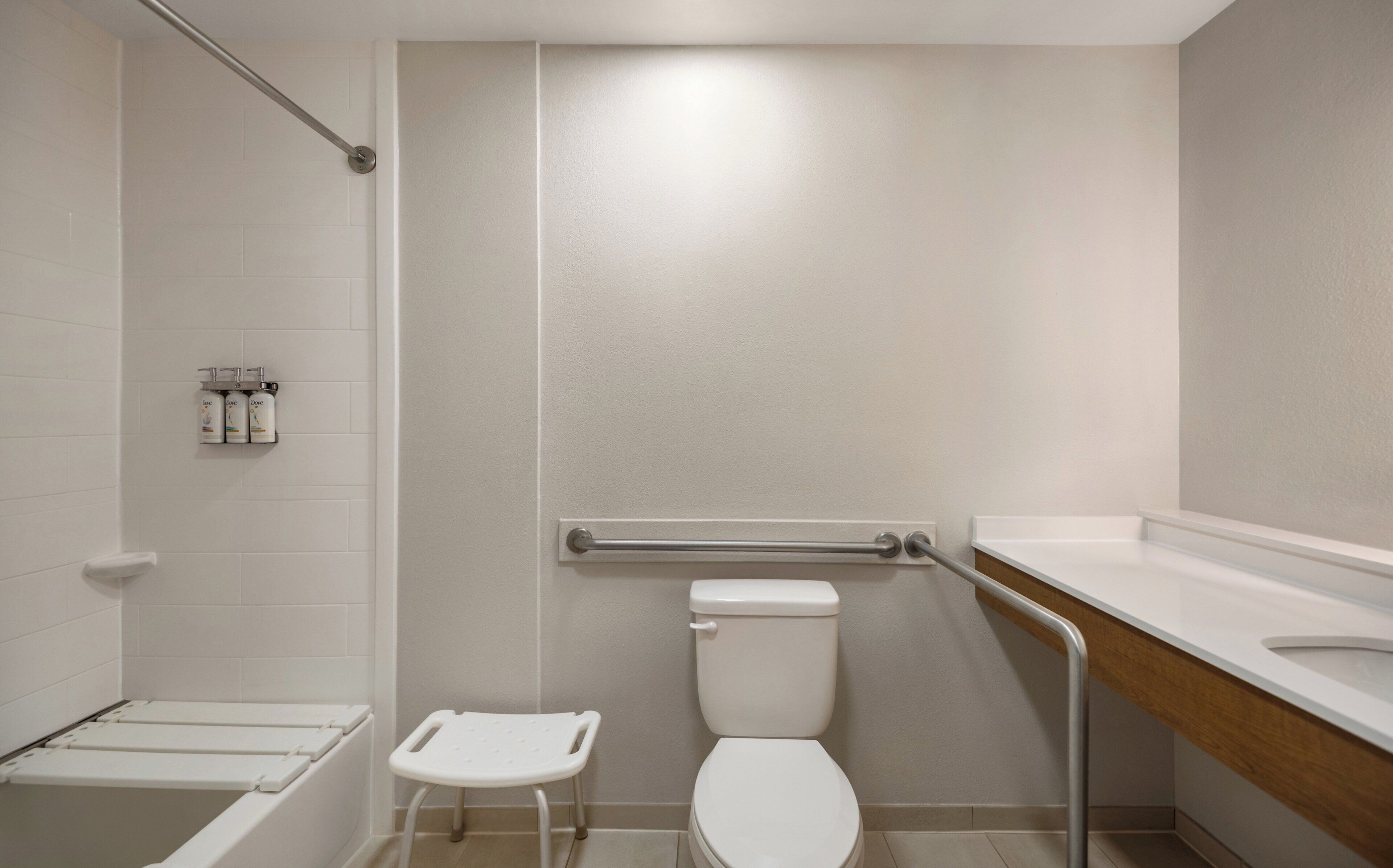 Une salle de bain avec des toilettes blanches, un espace douche et un lavabo.