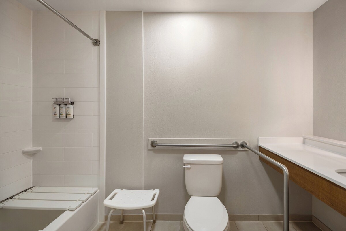 Ein Badezimmer mit Toilette, Duschbereich und Waschbecken.