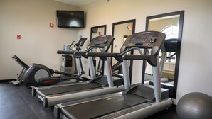 A gym with treadmills, an elliptical, and a stationary bike.