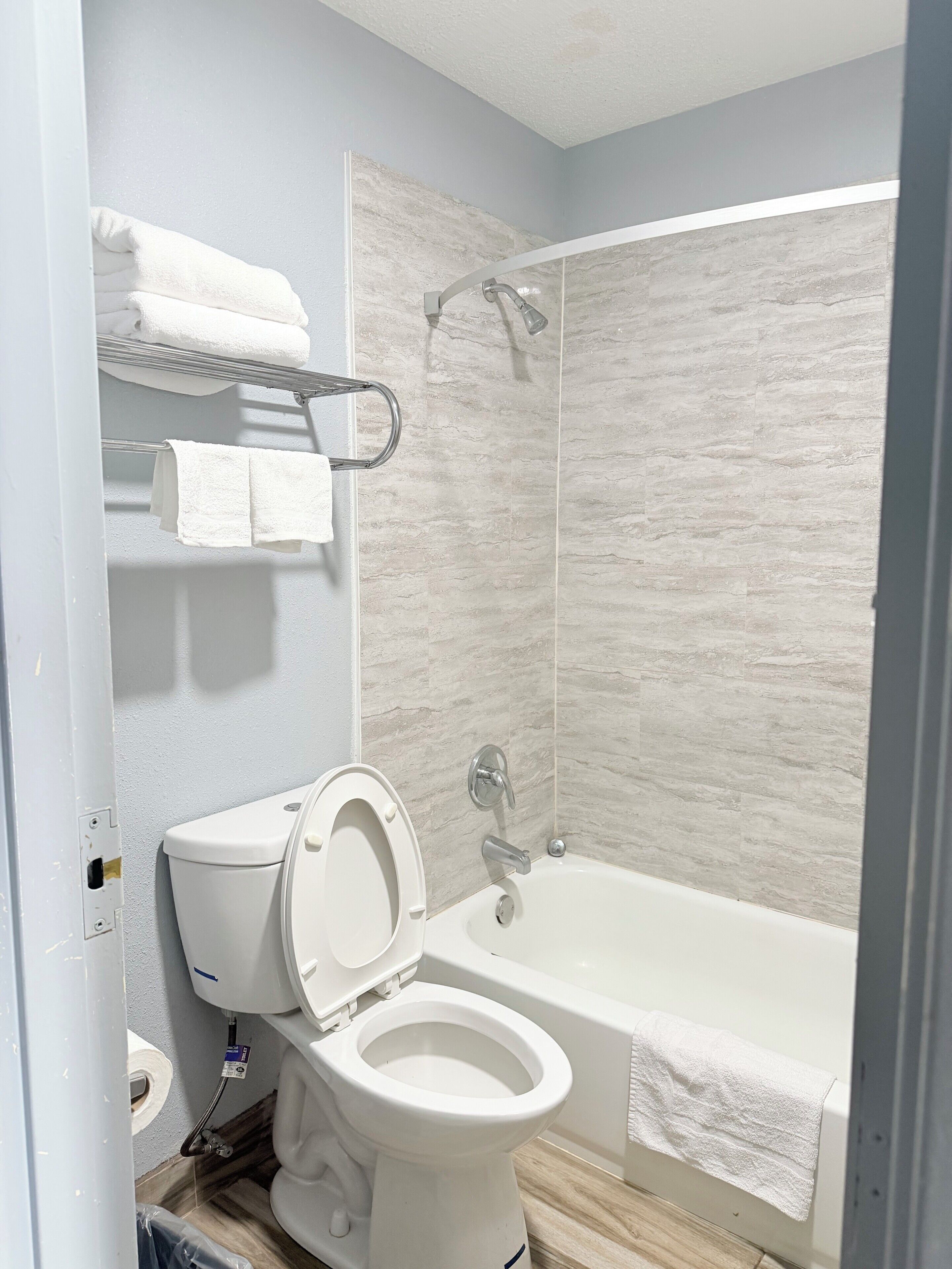 Une salle de bain moderne équipée de toilettes, d’une douche et d’une baignoire.