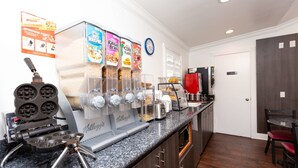 A breakfast bar with a waffle maker, a coffee machine, and a cereal dispenser.