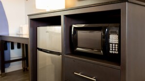 A kitchen with a built-in microwave and refrigerator.
