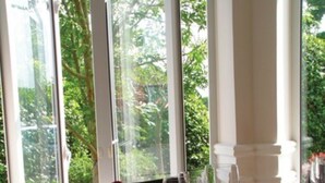A dining table set with multiple wine glasses, plates, and cutlery, with a view of greenery through large windows. - The Hickstead Hotel (Haywards Heath)