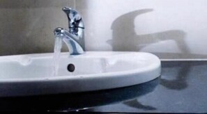 A bathroom sink with running water.