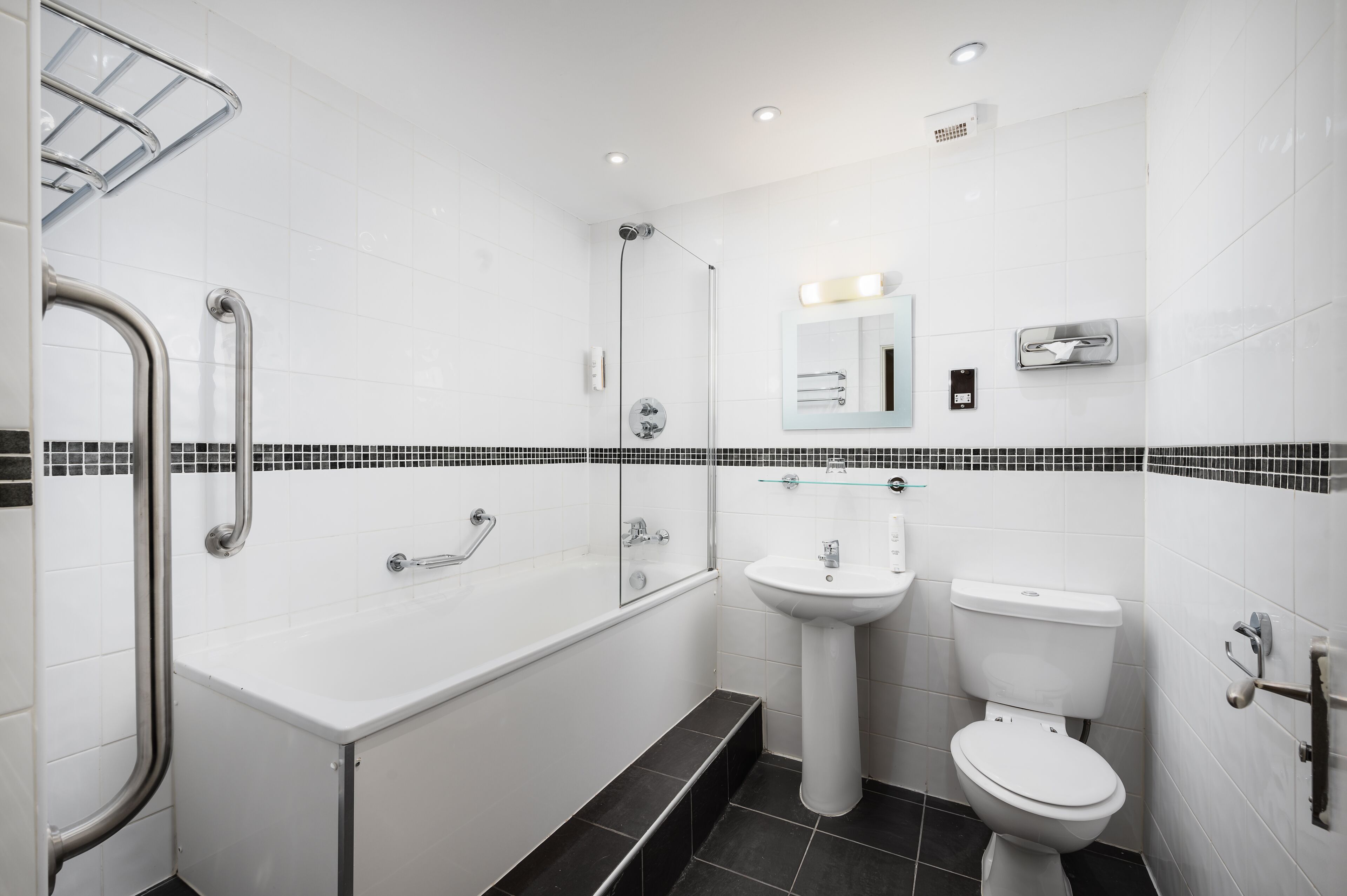 Un bagno moderno con vasca, lavabo e water.