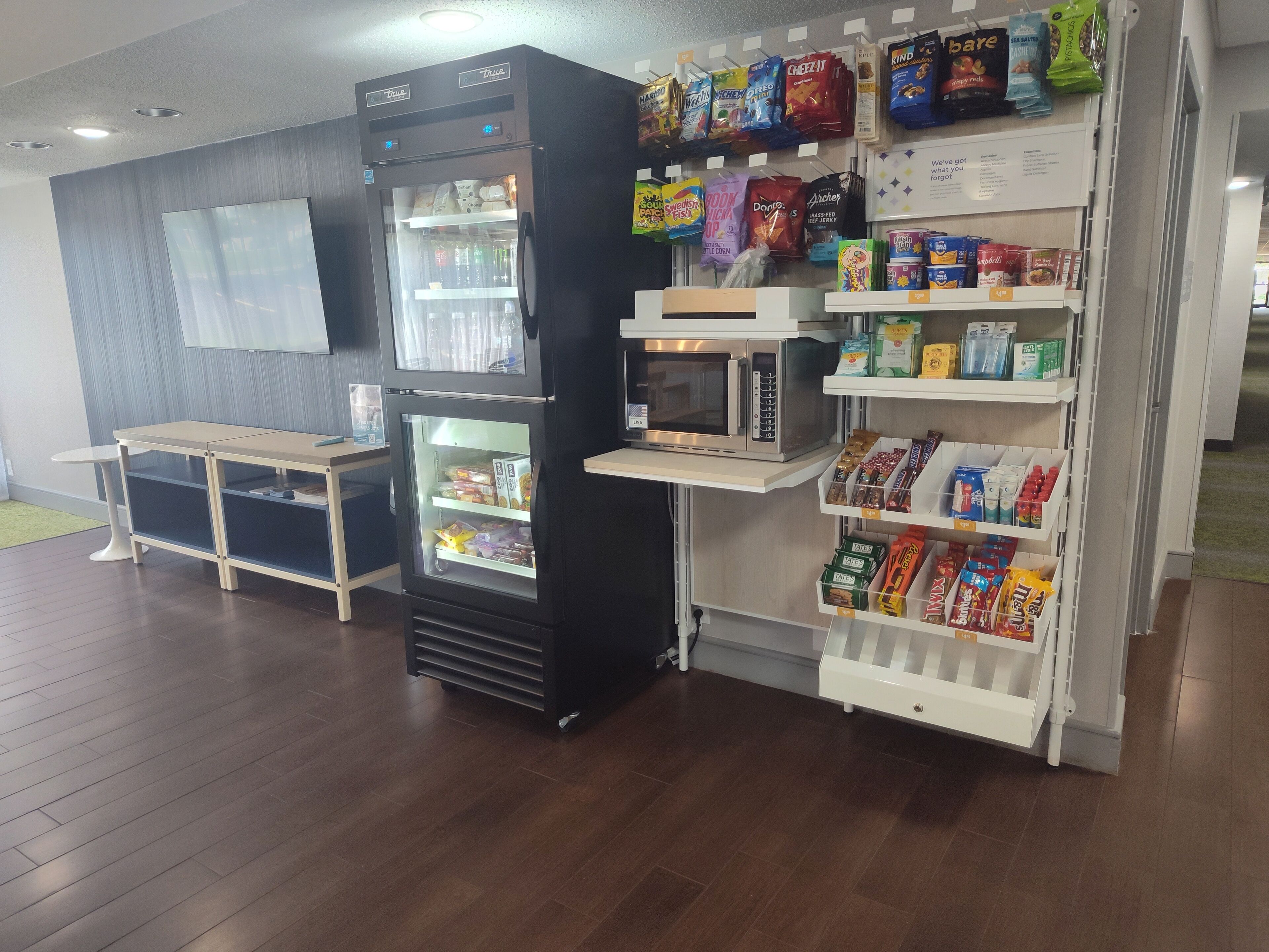 A vending machine area with snacks, a microwave, and a refrigerator.