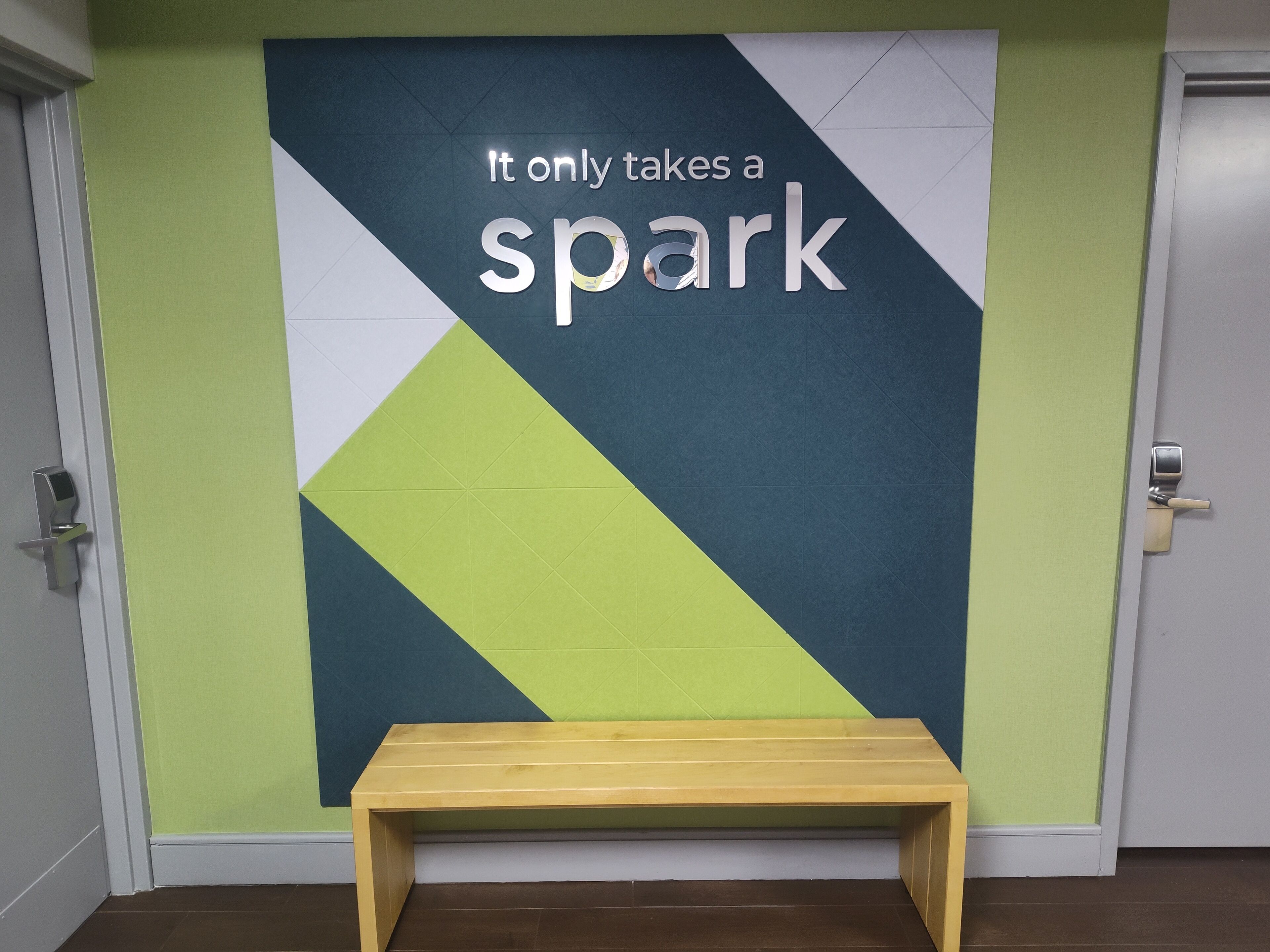 A wall with a motivational quote and a wooden bench.